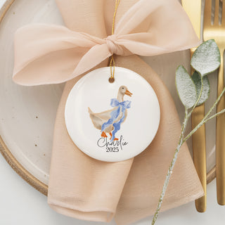 Custom ceramic ornament featuring a watercolor duck with a blue bow, personalized with baby name "Charlie" and year 2025 – unique keepsake gift for newborns and families.