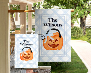 Personalized Halloween garden flag with jack-o-lantern and family name "The Wilsons" in blue gingham background.