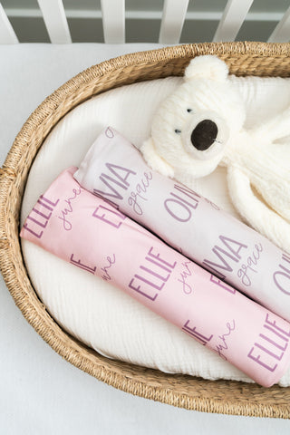 Soft pink personalized baby girl swaddle blanket with matching newborn hat – perfect for hospital photos and coming-home outfits.