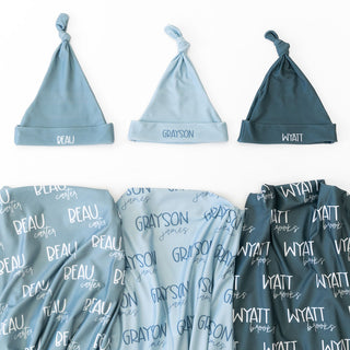 Personalized newborn swaddle blanket in soft blue with matching knotted hat