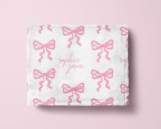 Personalized baby girl blanket with pink bow pattern and custom name in soft minky fabric