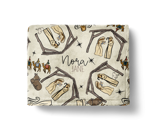 Personalized nativity scene Christmas blanket with manger, Holy Family, wise men, and animals on a neutral background, customized with the name “Nora Jane.”