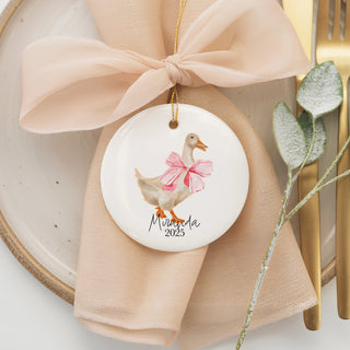 Custom ceramic ornament featuring a watercolor duck with a pink bow, personalized with baby name “Miranda” and year 2025 — a sweet holiday keepsake.