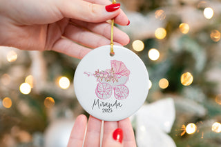 Personalized ceramic ornament with pink baby stroller and flowers, custom name “Miranda” and year 2025 — perfect baby’s first Christmas keepsake.