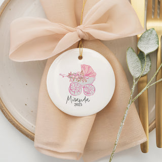 Custom baby carriage ornament in pink with floral accents, personalized with baby name and year for a timeless newborn or holiday gift.
