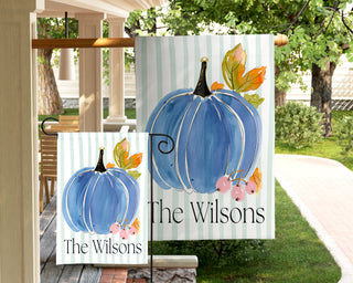 Custom fall garden flag with a watercolor pumpkin, autumn foliage, and personalized family name for farmhouse porch decor.