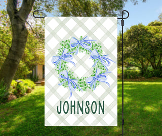 Farmhouse-style outdoor flag with greenery wreath and personalized last name