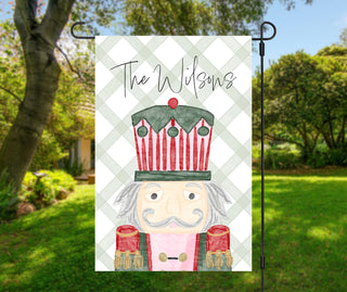 Personalized Christmas garden flag featuring watercolor nutcracker soldier on green gingham – The Navy Knot holiday décor