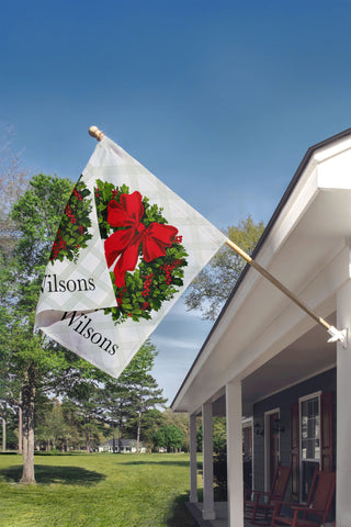 Custom family Christmas wreath flag featuring red ribbon and holly berries – outdoor holiday decoration