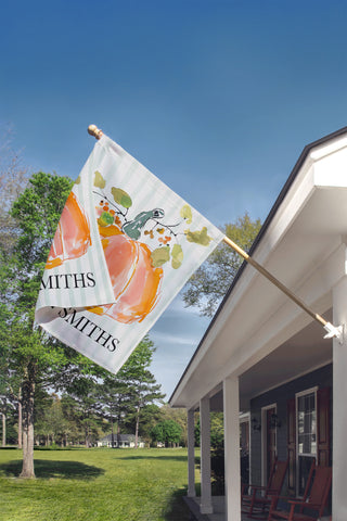 Custom fall garden flag with a watercolor pumpkin, autumn foliage, and personalized family name for farmhouse porch decor.