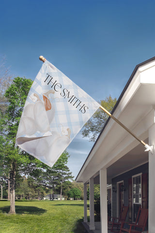 Custom garden flag with a boxwood topiary, decorative chinoiserie planter, and personalized family name for elegant porch decor.